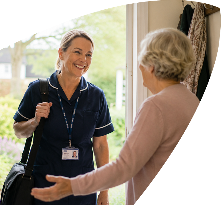 A smiling nurse with a shoulder bag greets an older woman at her door, representing the compassionate care provided by Mayo Roscommon Hospice. The nurse wears a navy uniform and ID badge. The scene is warm and welcoming, with greenery visible outside.