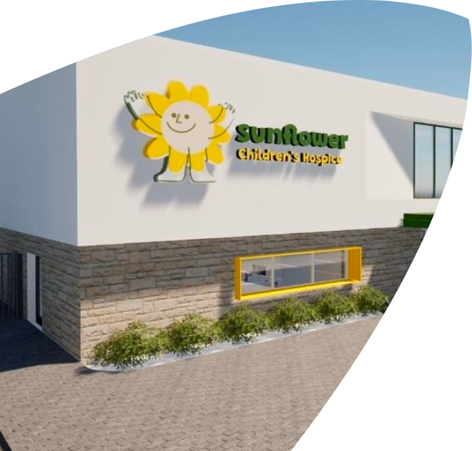 A building with a sign that reads Sunflower Children's Hospice and features a smiling sunflower character above a window and some plants, reminiscent of the welcoming atmosphere found at places like Mayo Roscommon Hospice.